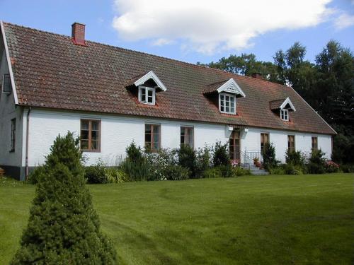 Biały dom z czerwonym dachem i dziedzińcem w obiekcie Bo i Remmarlöv w mieście Eslöv