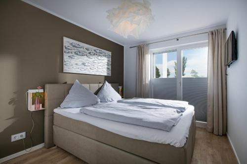 1 dormitorio con 1 cama grande y ventana en Strandgut, en Olpenitz
