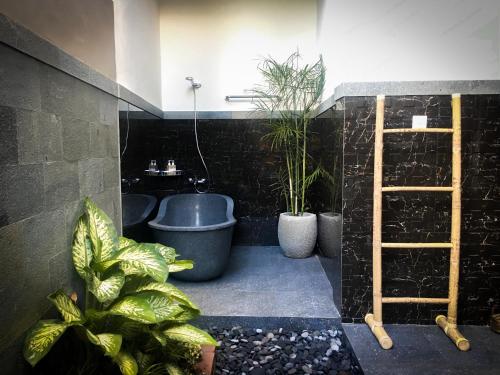 une salle de bains avec des plantes en pot et une échelle dans l'établissement Umah Kayu Ubud, à Ubud