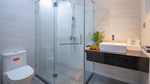 La salle de bains est pourvue d'une douche, de toilettes et d'un lavabo. dans l'établissement HSuites Hotel and Apartment, à Đà Nẵng