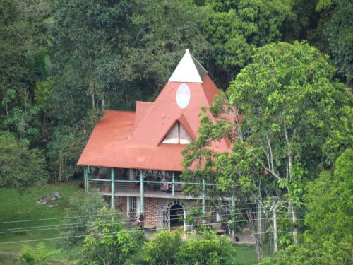 a house with a red roof on top of a hill at La Posada del Cucú in Salento