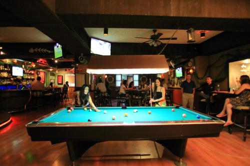 a pool table in a bar with people playing at Wild Orchid Beach Resort in Olongapo