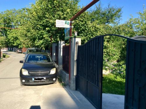 a car parked on a street next to a fence at Taripiri in Ambrolauri
