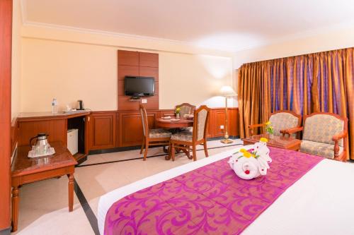 a hotel room with a bed with a pink rug at Hotel Annamalai International in Puducherry