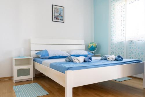 a bedroom with a large white bed with blue sheets at Cro Behar 2 Apartments in Sveti Petar