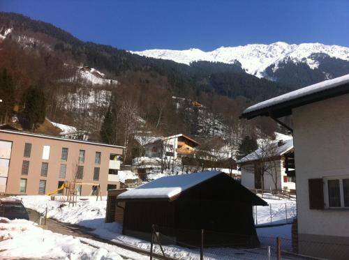 a building with snow on it in front of a mountain at Landhaus Fuchsenstube in Schruns-Tschagguns