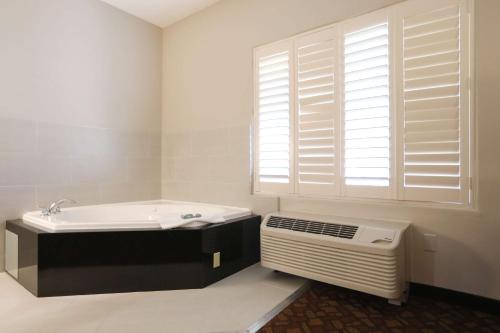 baño blanco con lavabo y ventana en Best Western Lanai Garden Inn & Suites en San José