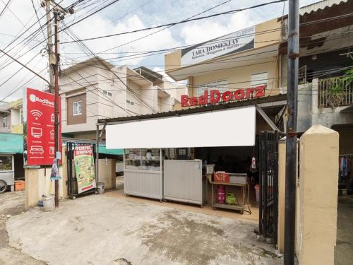 a store with a white awning in front of a building at RedDoorz at Tara Homestay Palembang in Palembang