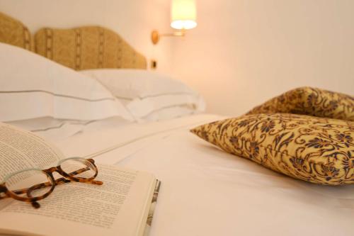 a book and a pair of glasses sitting on a bed at Best Western Hotel Acqua Novella in Spotorno