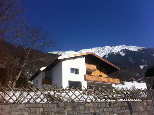 a white house with snowy mountains in the background at Landhaus Fuchsenstube in Schruns-Tschagguns