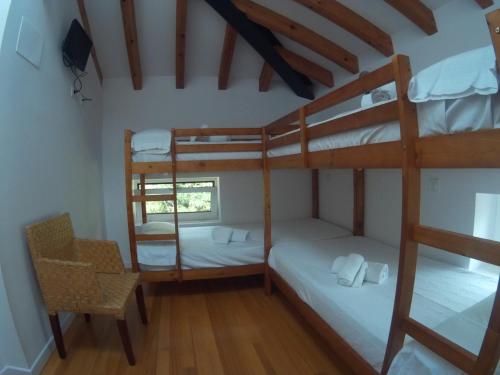 a room with two bunk beds and a chair at Castro Urdiales - LA VIEJA ESTACIÓN - Cerca de Bilbao in Castro-Urdiales