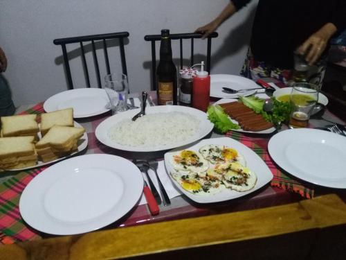 a table with white plates and food on it at Viyanga Homestay in Ella