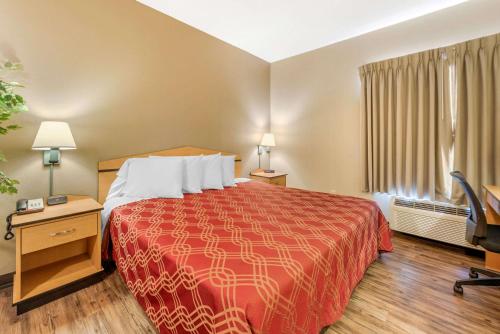 a hotel room with a bed and a television at Econo Lodge Airport/Colorado Springs in Colorado Springs