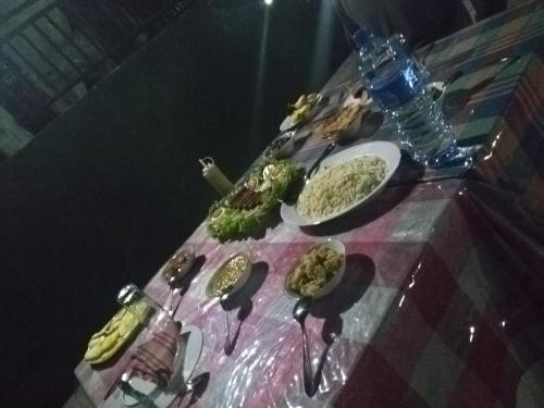a table with plates of food on a table at Viyanga Homestay in Ella