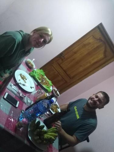 two people standing in a kitchen with a table with food at Viyanga Homestay in Ella