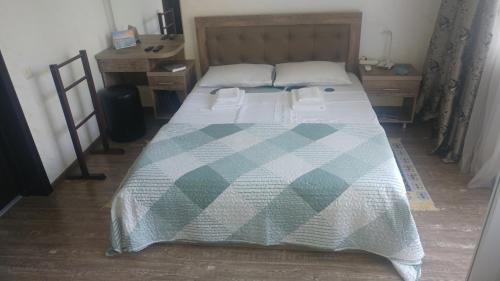 a bedroom with a bed with a checkered blanket at Villa Royal House in Makhinjauri
