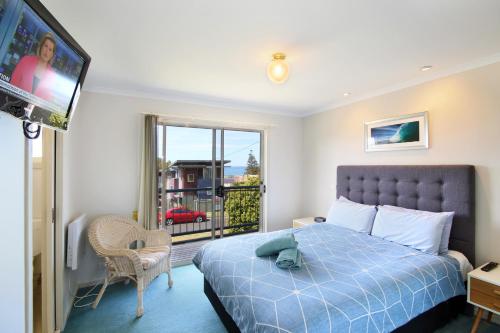 a hotel room with a bed and a balcony at Lorne Ocean Sun Apartments in Lorne