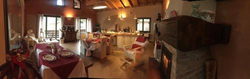 a room with tables and a kitchen in a house at B&B La Piazzetta in Castiglione dei Pepoli