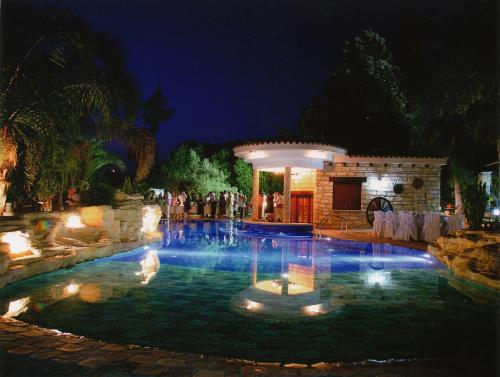 a swimming pool with a fountain at night at De Michanna in Anarita