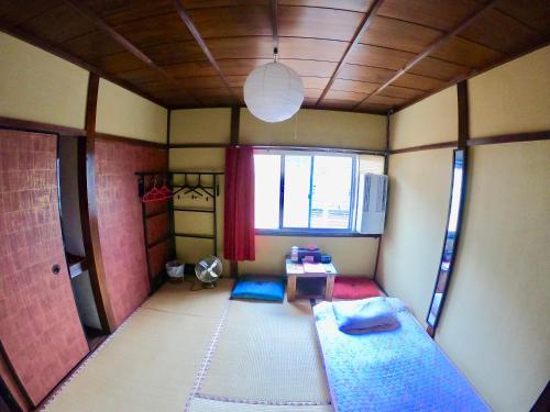 um pequeno quarto com uma cama e uma janela em Benidaruma - Ichigo Daifuku em Quioto