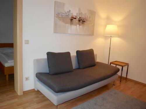 a couch with two pillows on it in a room at Charmantes Apartment mit Terrasse zum Garten nahe Wien in Gumpoldskirchen
