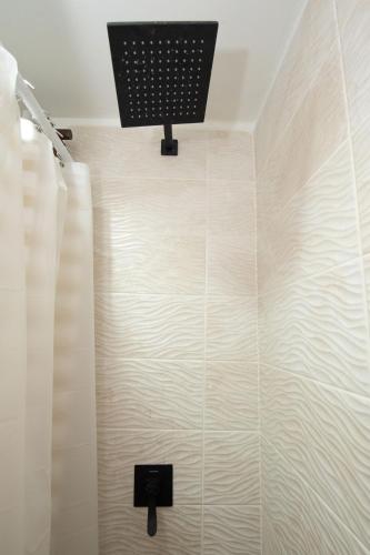 a bathroom with a shower with a light on the wall at La Casa de Paz Hotel in San Pedro