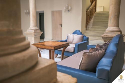 a living room with two blue chairs and a table at Hotel Palacio De Úbeda 5 G.L in Úbeda
