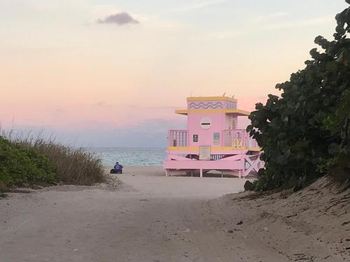 a pink building on the beach near the ocean at The King David Condos in Miami Beach