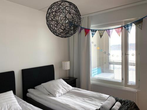 a bedroom with a bed and a window with flags at The Harbour Apartments in Jyväskylä
