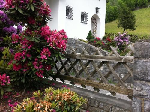 a fence with flowers in front of a building at Landhaus Fuchsenstube in Schruns-Tschagguns
