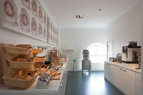 a kitchen with a counter with baskets of bread at Hotel Künstlerhaus in Norderney