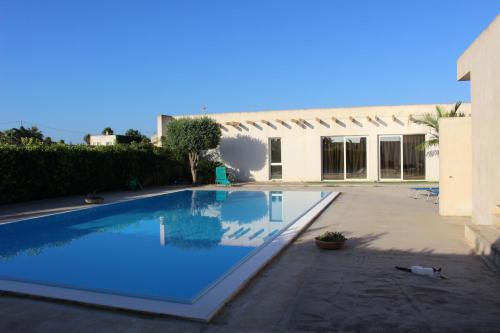 a large swimming pool in front of a house at Villetta di Nonna Giovanna in Marsala