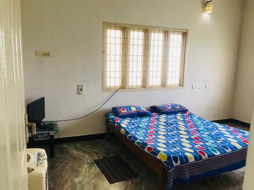 a bedroom with a bed and a television in it at Bethel house in Chennai