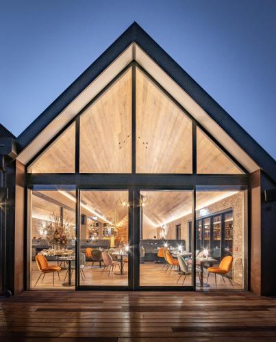 an open living room with large windows and a dining room at Kamana Lakehouse in Queenstown