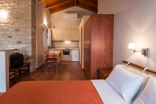 a hotel room with a bed and a kitchen at Enastron Villas in Kyparissia