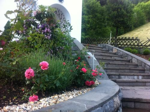 a set of stairs with pink flowers in a garden at Landhaus Fuchsenstube in Schruns-Tschagguns