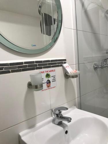 a bathroom with a white sink and a mirror at Pension Haus Baron 4 Mühlheim in Mühlheim
