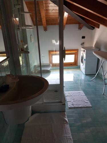 Un baño con lavabo y lavadora. en Appartamento Modenese 8, en Peschiera del Garda