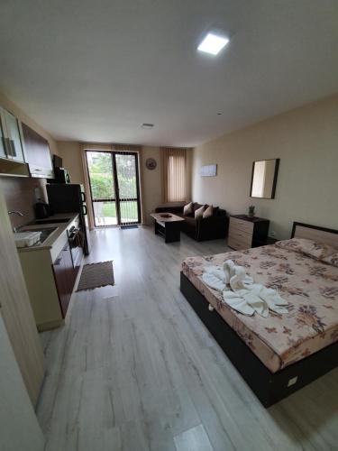 Una habitación grande con una cama y una cocina. en Orchid Studio, en Golden Sands