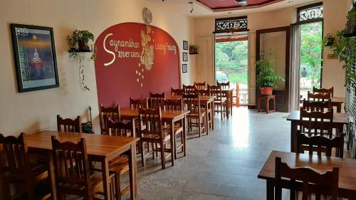 ein Speisesaal mit Tischen und Stühlen in einem Restaurant in der Unterkunft Saynamkhan River View in Luang Prabang