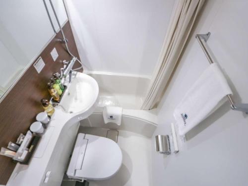 een kleine badkamer met een toilet en een wastafel bij HOTEL LiVEMAX Nigata Nagaoka Station in Nagaoka