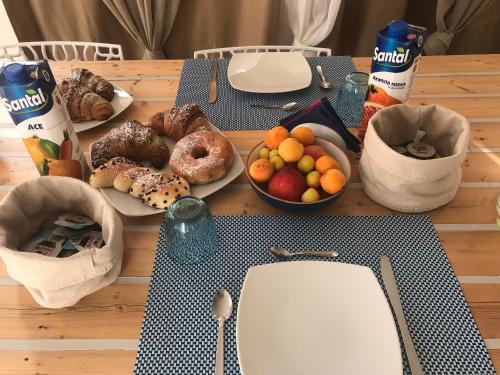 a table topped with plates of donuts and fruit at B&b IL FIOCCO E LA RANDA in San Vito lo Capo
