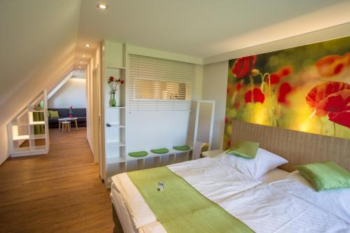 ein Schlafzimmer mit einem Bett und einem Wandgemälde in der Unterkunft Gasthof Linden & Wildkräuterhotel in Windelsbach
