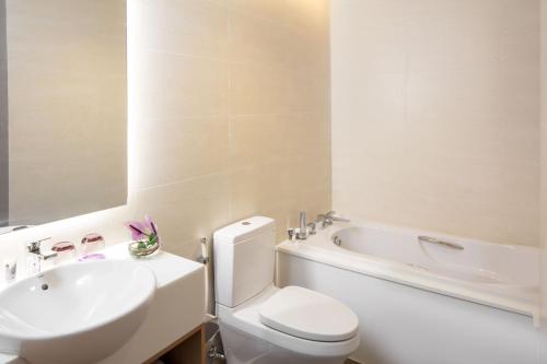 a bathroom with a toilet and a sink and a tub at Mercure Hai Phong in Hai Phong