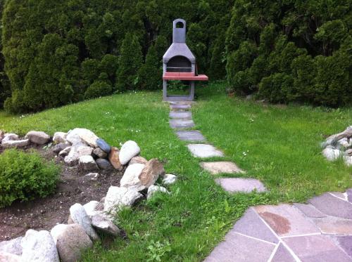 a garden with a stone path and a bird house at Landhaus Fuchsenstube in Schruns-Tschagguns