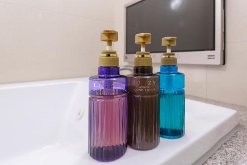 three different colored bottles sitting on a bathroom counter at Lucky Sun in Nishinomiya