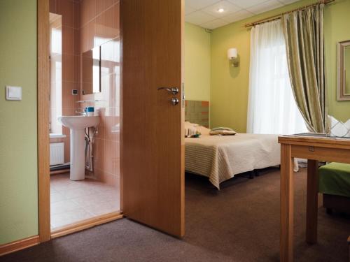 コルピノにあるHotel Uyutnayaのベッドルーム1室(ベッド1台、バスルーム付)