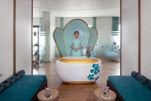 a room with a tub with a woman in a mirror at Mercure Hai Phong in Hai Phong