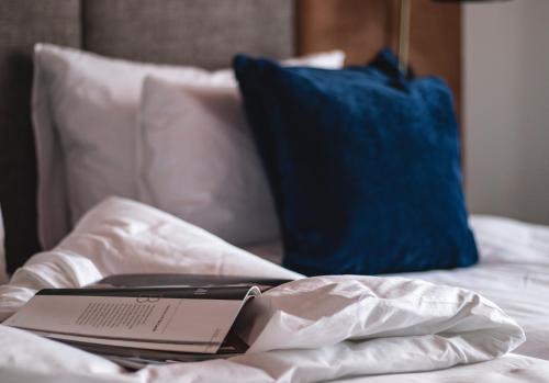 a laptop computer sitting on a bed with a blue pillow at The Barrister in Valletta