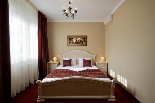 a bedroom with a bed and a chandelier at Hotel Romanov in Sochi